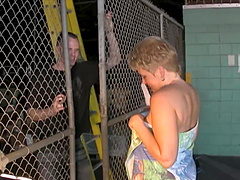 A blonde mature woman with big natural tits makes a blowjob outdoors