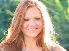 A beautiful redhead with long hair and natural breasts performs solo.